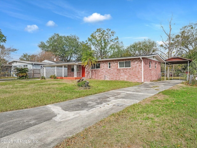 ranch-style home featuring a carport and a front lawn