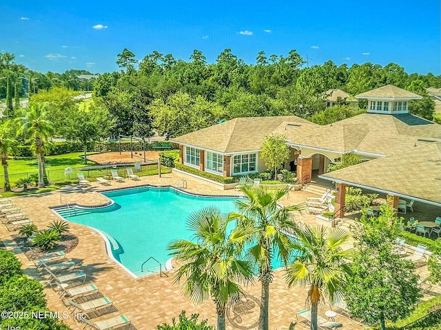 pool featuring a patio area, fence, and a lawn