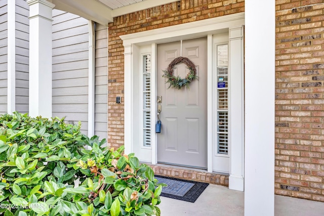 entrance to property featuring brick siding