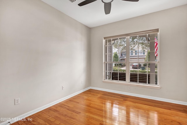 spare room with ceiling fan, baseboards, and hardwood / wood-style floors