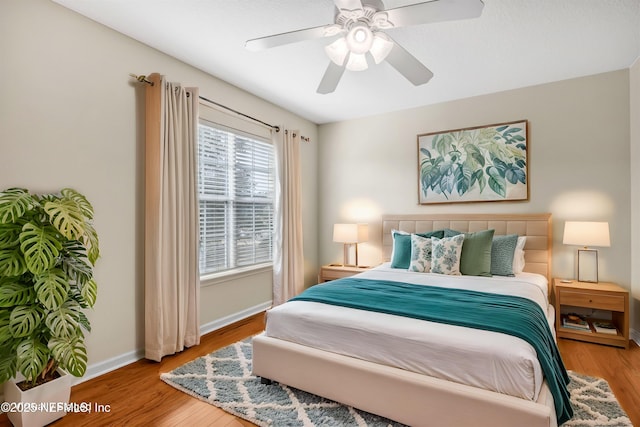 bedroom featuring wood finished floors, baseboards, and ceiling fan