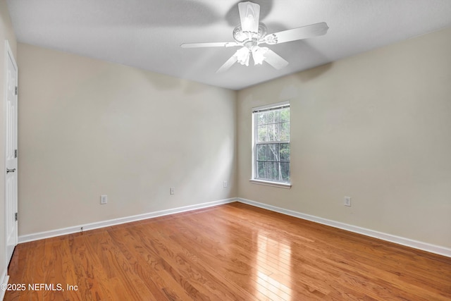 spare room with light wood finished floors, ceiling fan, and baseboards