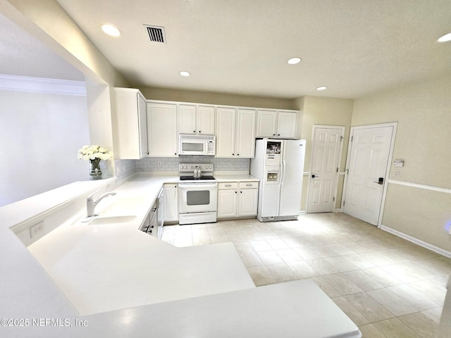 kitchen featuring white appliances, visible vents, a sink, light countertops, and tasteful backsplash