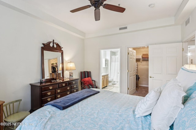 bedroom featuring a walk in closet, a closet, ceiling fan, and ensuite bathroom