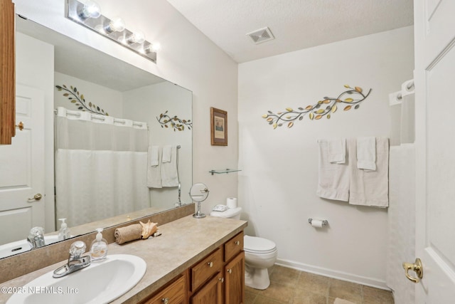 bathroom featuring vanity, a textured ceiling, and toilet