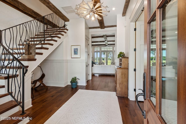 foyer entrance with beamed ceiling, french doors, dark hardwood / wood-style flooring, and an inviting chandelier