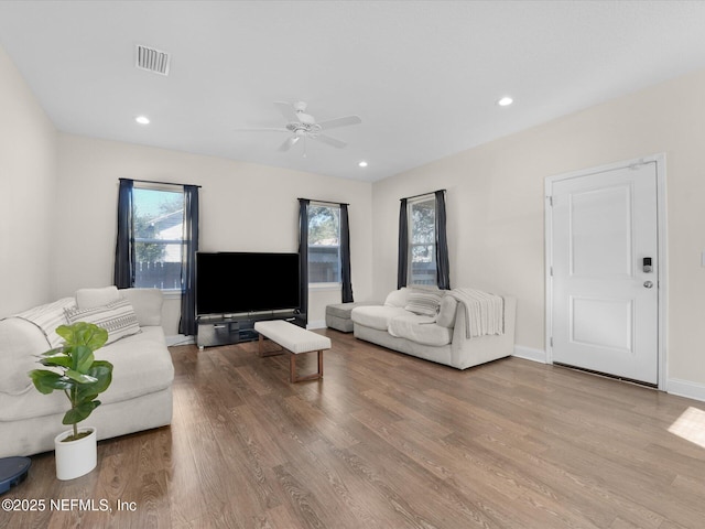 living room with ceiling fan and light hardwood / wood-style flooring