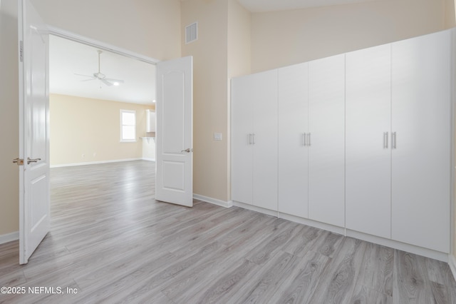 unfurnished bedroom featuring high vaulted ceiling and light hardwood / wood-style floors