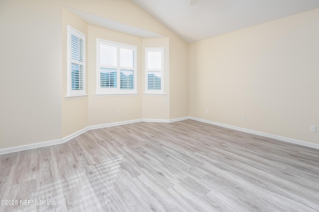 empty room featuring lofted ceiling and light hardwood / wood-style floors