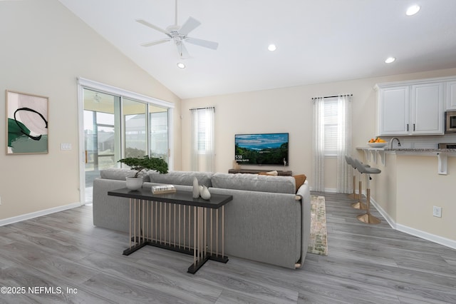 living room featuring a wealth of natural light, light hardwood / wood-style floors, and ceiling fan