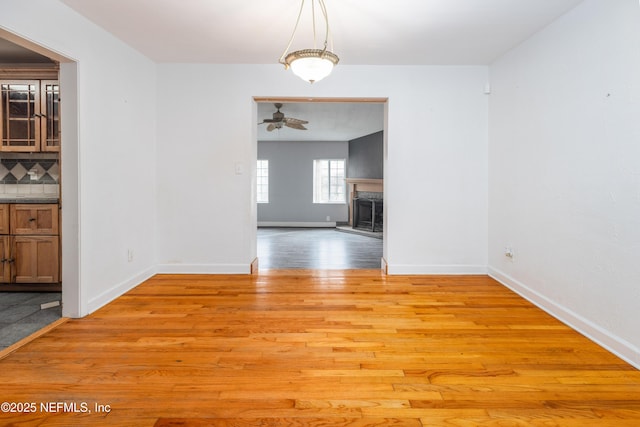 unfurnished dining area featuring ceiling fan and light wood-type flooring