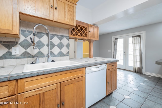 kitchen featuring tasteful backsplash, dishwasher, sink, light tile patterned floors, and french doors