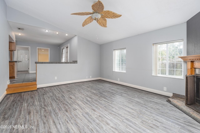 unfurnished living room with ceiling fan, light hardwood / wood-style flooring, and vaulted ceiling