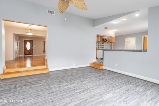 unfurnished living room with lofted ceiling and light wood-type flooring