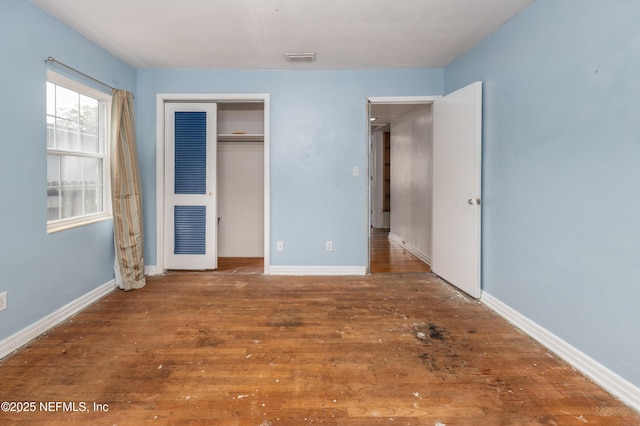 unfurnished bedroom with a closet and hardwood / wood-style floors