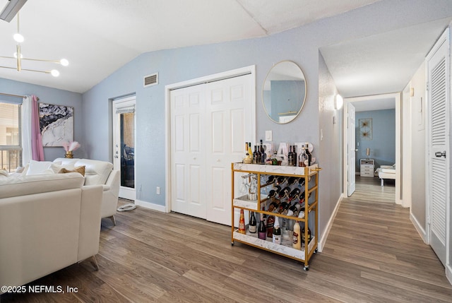 interior space with hardwood / wood-style floors, lofted ceiling, and a chandelier