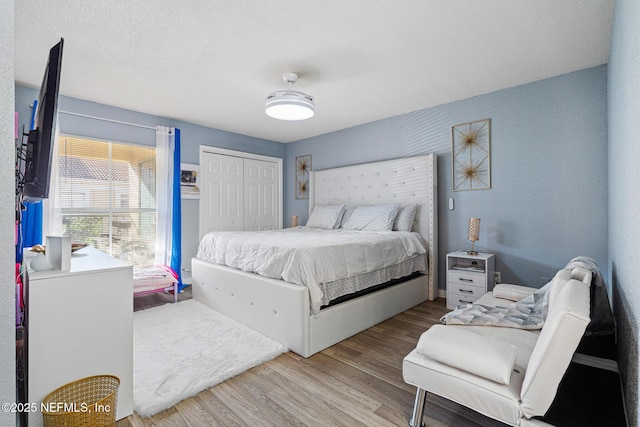 bedroom featuring light hardwood / wood-style flooring, a closet, and ceiling fan