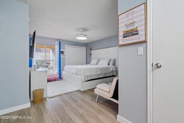 bedroom with light hardwood / wood-style floors and a closet