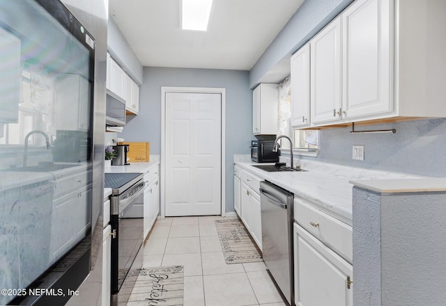 kitchen with white cabinetry, sink, light tile patterned flooring, and stainless steel appliances