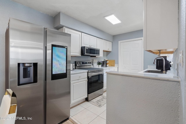 kitchen featuring white cabinets, light tile patterned flooring, sink, and appliances with stainless steel finishes