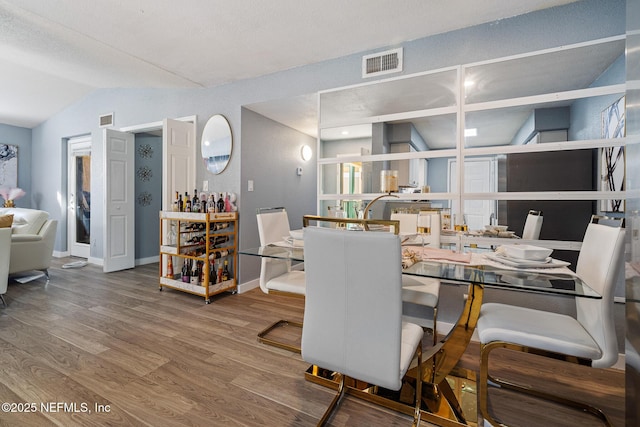 dining area with lofted ceiling and wood-type flooring