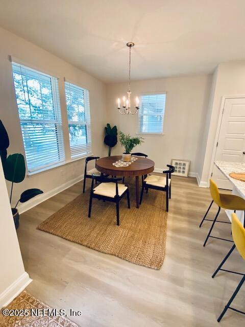 dining space featuring hardwood / wood-style flooring and a chandelier