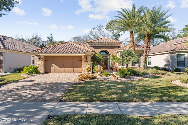 mediterranean / spanish home featuring a front lawn and a garage