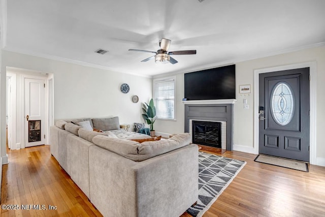 living room with ceiling fan, light hardwood / wood-style floors, and ornamental molding