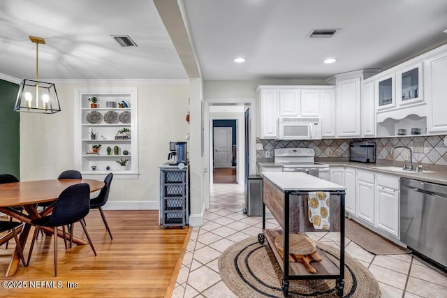 kitchen featuring light tile patterned floors, white appliances, white cabinetry, and sink