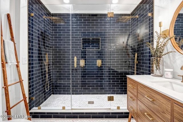 bathroom featuring vanity, a shower with shower door, and ornamental molding