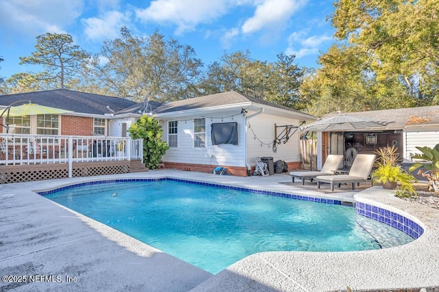 view of swimming pool featuring a patio area and a wooden deck