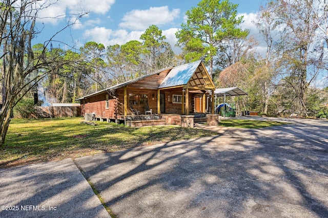 log home with a front lawn and a carport