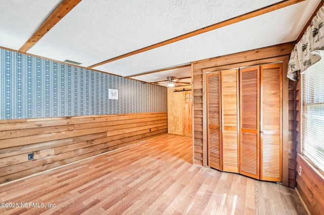 interior space featuring ceiling fan, a textured ceiling, and light hardwood / wood-style floors