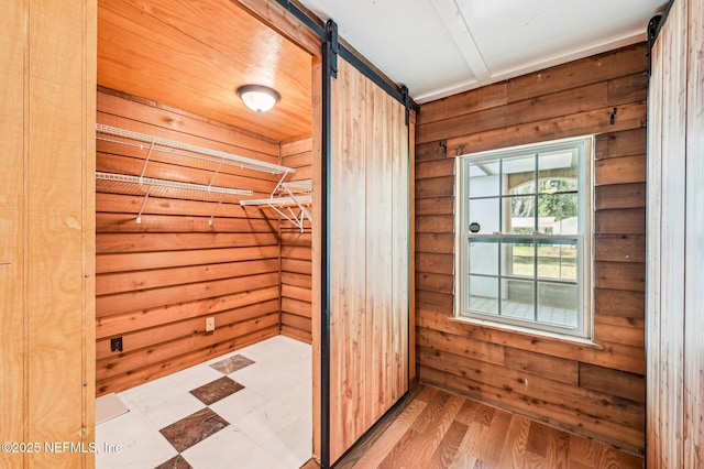 interior space with a barn door and wood walls