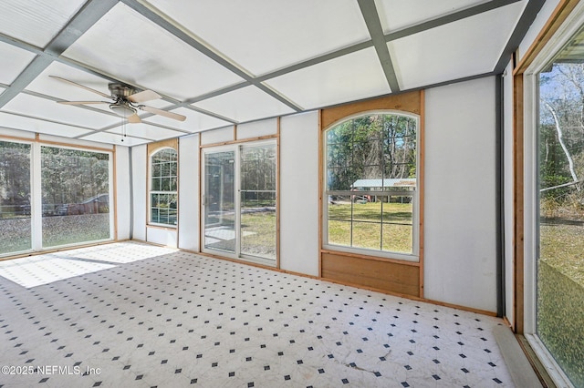 unfurnished sunroom featuring ceiling fan, plenty of natural light, and coffered ceiling