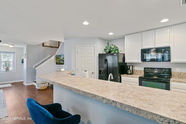 kitchen with white cabinetry, dark wood-type flooring, and black appliances