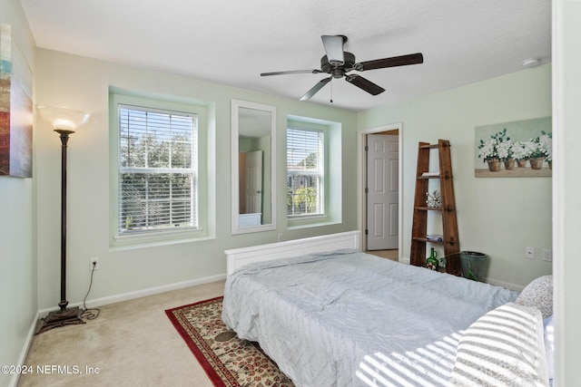 bedroom with ceiling fan and light colored carpet