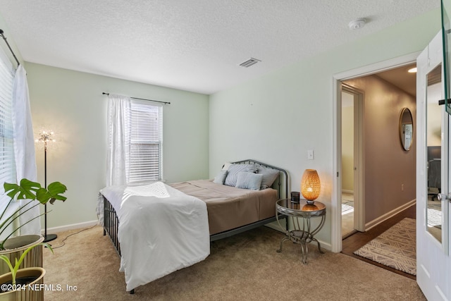 carpeted bedroom featuring a textured ceiling