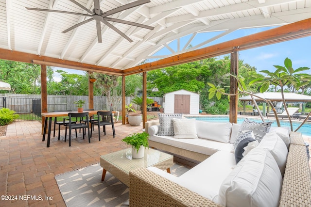 view of patio / terrace featuring outdoor lounge area, a gazebo, a storage shed, and a fenced in pool