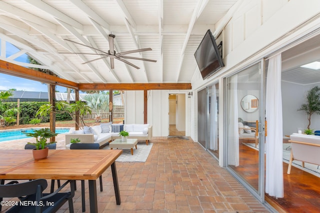 sunroom / solarium featuring lofted ceiling with beams and ceiling fan