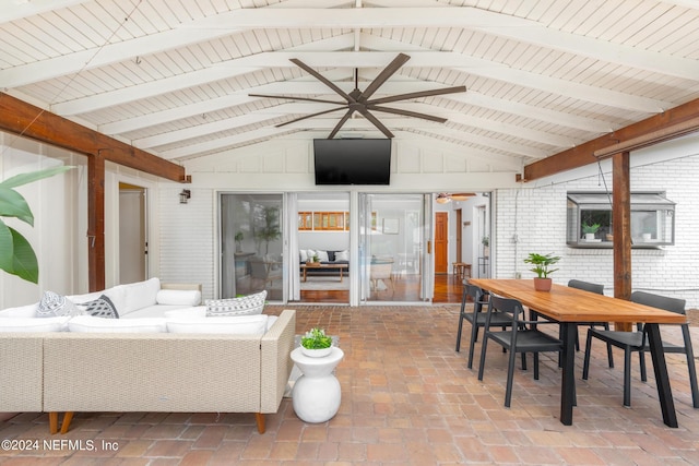 sunroom / solarium featuring vaulted ceiling with beams