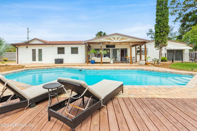 view of pool featuring a wooden deck and french doors