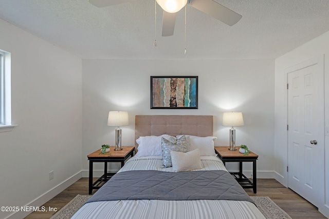 bedroom with wood-type flooring, a textured ceiling, and ceiling fan