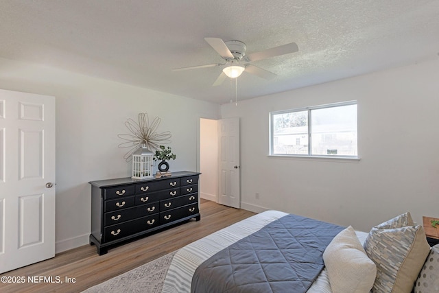 bedroom featuring ceiling fan, a textured ceiling, and hardwood / wood-style flooring