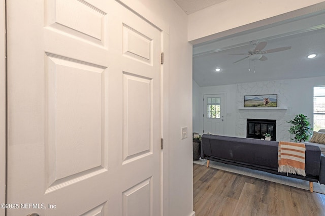 interior space featuring ceiling fan, light wood-type flooring, and a fireplace