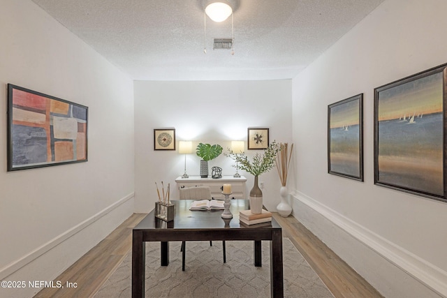 office area with wood-type flooring and a textured ceiling