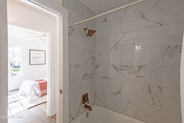 bathroom featuring hardwood / wood-style flooring and tiled shower / bath