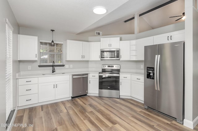 kitchen featuring white cabinets, decorative light fixtures, sink, and appliances with stainless steel finishes