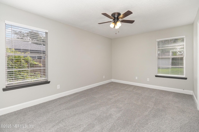 carpeted empty room with ceiling fan and a textured ceiling