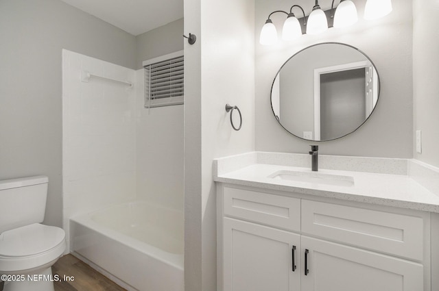 full bathroom featuring hardwood / wood-style floors, vanity, toilet, and shower / tub combination